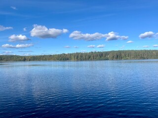 beautiful blue lake view, blue sky with white clouds reflections on the lake surface