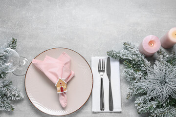 Christmas place setting with festive decor on grey textured table, flat lay. Space for text