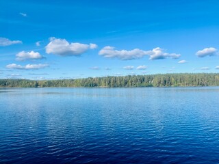 beautiful blue lake view, blue sky with white clouds reflections on the lake surface