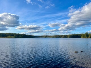 beautiful blue lake view, blue sky with white clouds reflections on the lake surface