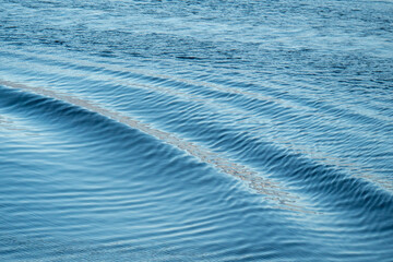 Wellenbewegung auf dem Wasser hinter einem Bott 