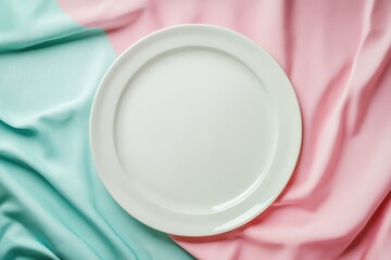 Bird s eye view of a blank white plate on a colored tablecloth leaving room for your design