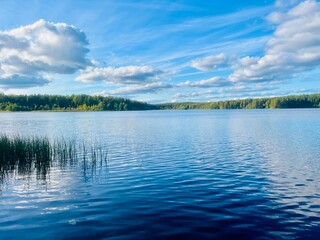 beautiful blue lake view, blue sky with white clouds reflections on the lake surface