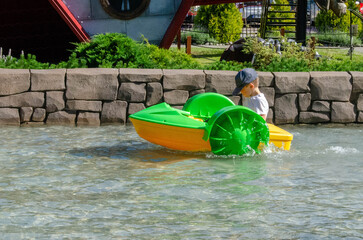 Kid playing rowing water paddle boat. Soft focus.