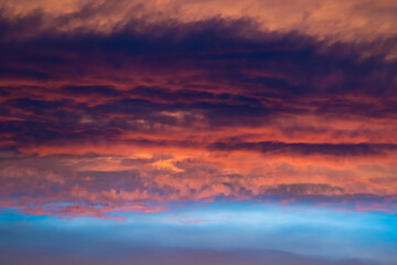 Crimson clouds in blue sky at sunset