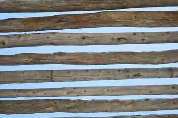 Horizontal wooden beams under bright sky