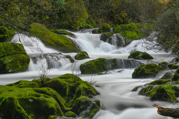 Waterfall in the mountain and rocks covered with moss