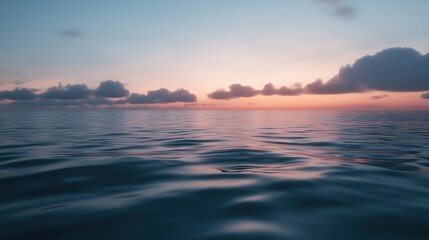 Naklejka premium The ocean is calm and the sky is a beautiful shade of pink. The clouds are scattered throughout the sky, creating a serene atmosphere