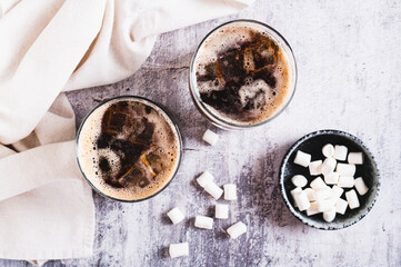 Fusion drink of cola and marshmallow in glasses on the table top view