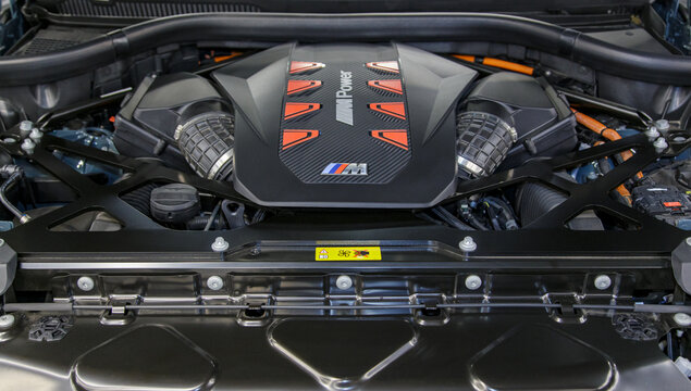 BMW XM engine - hybrid, plug-in V8 engine. Engine motor M POWER of BMW XM 50e close-up with emblem. BMW sport engine or motor under vehicle hood.