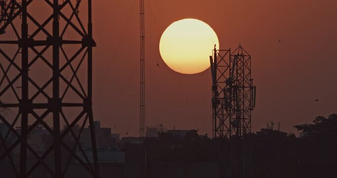 Jaipur, Rajasthan, India. Sunset Sun Shining. Sunset. Evening Sun Sets Over Horizon. Cityscape Urban Skyline. The Sun Sets Against Backdrop Of Telecommunication Towers. Orange Bright Sky. Kites Soar