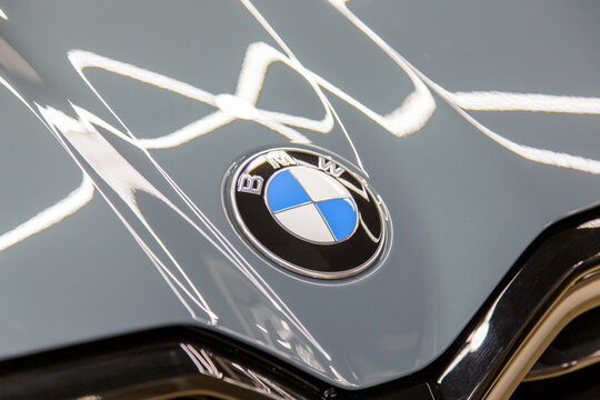 BMW XM logo on gray car  Hood and black kidney grille closeup. Emblem of BMW i on hood of hybrid car close up. BMW XM 50e hybrid logo on car hood. 