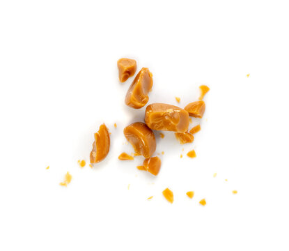Broken caramel candies isolated, toffee caramel crumbs, round hard milk confectionery pieces