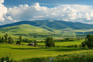 Obraz premium Beautiful green valley landscape with mountains, blue sky and white clouds. Rural countryside scenic view.