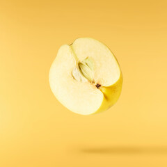Fresh ripe yellow Quince fruit  falling in the air isolated on yellow background. Food levitation or zero gravity conception