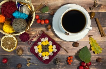 Cozy autumn photo with a cup of coffee, flashlight, crocheting, leaves and autumn decor