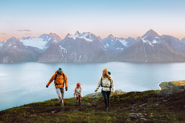 Family travel lifestyle - mother, father, and child hiking together in mountains adventure trip in Norway, parents and kid on active vacations outdoor climbing peak, healthy lifestyle tourism hobby