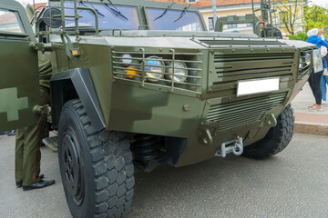 Wheeled armored infantry vehicle. A protected military vehicle with armored windows and headlight protection from shell fragments.