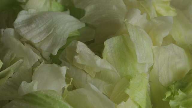 Pile of chopped up iceberg lettuce close up rotating. Vegetables and healthy eating concept 