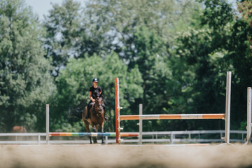 Rider practicing horse jumping in an outdoor arena, focusing on equestrian training and equestrian sport techniques.