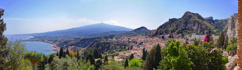 Fototapeta premium Coast of Sicily, Giardini Naxos and Taormina view. Landscape panorama with Mount Etna in the back on a sunny summer day. 