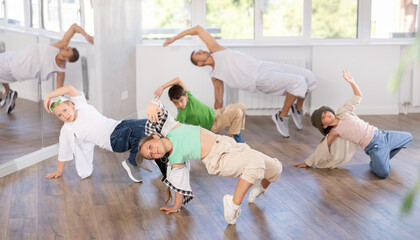 Group of active children dancers having break dance training at dance studio