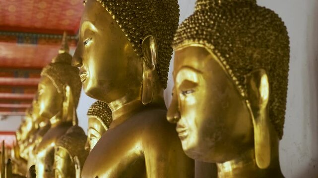 Row of golden Buddha statue in Wat Pho Temple Complex in Bangkok city, Thailand, Asia. Temple of the Reclining Buddha. Popular tourist landmark