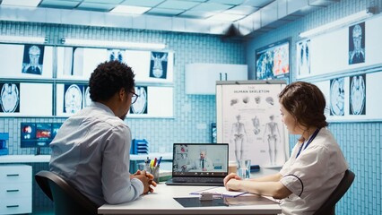 Physician entering a video call with specialist to discuss diagnostic report, asking the expert for...