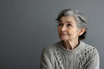 Senior woman isolated on gray background. Studio portrait. Dementia and Alzheimer's disease concept. Memory loss awareness. Banner with copy space