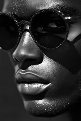 Close-up of an African male face in sunglasses with dramatic lighting creating high contrast shadows. © umut hasanoglu