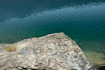 Flat Rock Overhangs The Blue Water Of Bowman Lake