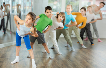 Children perform bends, stretches and squats to prepare their muscles and body. Students...