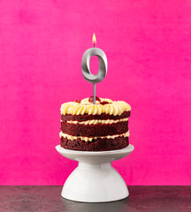 Birthday cake with number 0 candle - Red velvet on a fuchsia background.