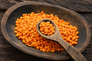 Raw red lentils in a bowl and spoon - Lens culinaris.