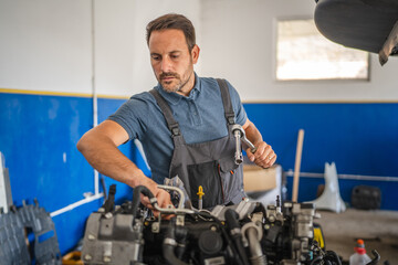 Car mechanic work on a car engine in an auto repair workshop