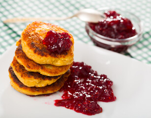 Image of stack of fried quark pancakes with jam served at plate