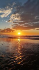 Obraz premium A beautiful sunset over a calm ocean with golden hues reflecting on wet sands and dispersed clouds in the sky.