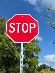 Bright red and white stop sign against a blue sky