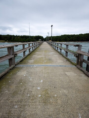Obraz premium Fishing pier dock at an ocean with wooden rails