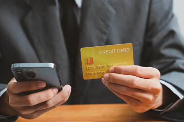 Close up Male hands holding credit card and smartphone, man paying online, credit card shopping, using banking service, entering information, shopping, ordering in internet store, doing secure payment