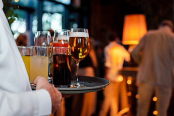 Waiter holding tray with beers and sodas at an elegant event