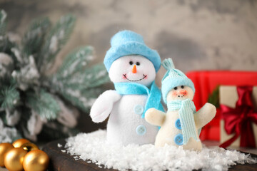 Funny snowmen figures and Christmas decor on table