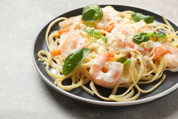 Tasty pasta with shrimps on light grey table, closeup