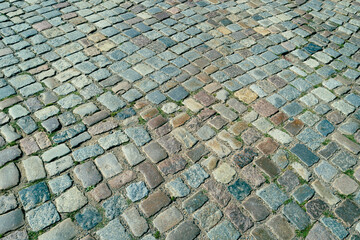 Fototapeta premium Background of bricks road. Background with bricks road. Stone cladding pavement. Brick surface background. Rough brick road. Stone pavement texture.