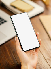 Mockup image of a woman using smartphone with blank screen on wooden table