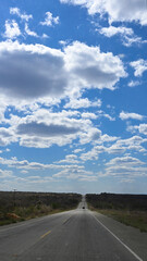road with blue sky clear day paved highway with farms vegetation mountains clouds