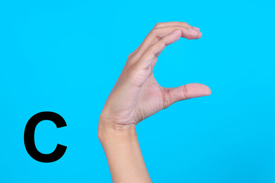 Finger Spelling the Alphabet in American Sign Language (ASL). The Letter C Over Blue Background
