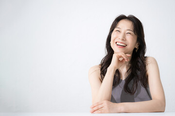 Fototapeta premium A beautiful 50-something woman with a cheeky smile for images such as beauty looking up thinking