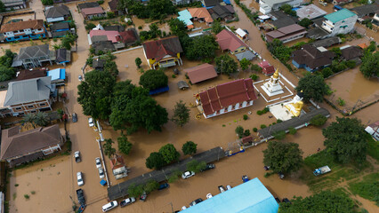 Fototapeta premium Aerial view of suburb area in Chiang Rai downtown flooding by Kok river after typhoon Yagi has swept Southeast Asia.