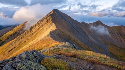 Fototapeta premium A stunning mountain landscape at sunset with vibrant colors and dramatic cloud formations.